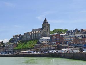 eine Stadt mit einem Gebäude auf einem Hügel neben dem Wasser in der Unterkunft Villa Mona Studio Falaises quartier des Cordiers in Le Tréport
