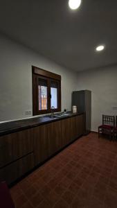 an empty kitchen with a sink and a window at Hostel Raíces in La Matea