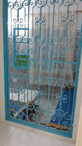 Una puerta con una puerta de acero azul en un edificio. en DAR Mahdia, en Túnez