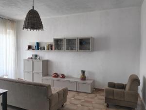 a living room with a couch and chairs and a table at Chiaro di Luna in Budoni