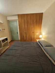 a bedroom with a large bed and a wooden cabinet at Habitación Privada Céntrica en Providencia a pasos del Metro Manuel Montt in Santiago