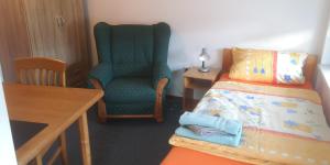 a room with a chair and a bed and a table at Vermietung Gisl in Wiesent