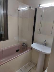 a bathroom with a sink and a glass shower at Grande maison avec jardin in Liffol-le-Grand