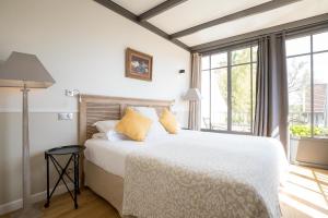 a bedroom with a large white bed with yellow pillows at Villa Louise in Aloxe-Corton +24 photos