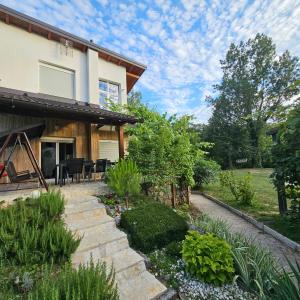 a home with a patio and landscaping at Vikendica na Sani Datea in Sanski most