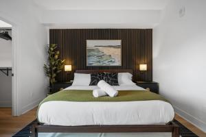 una camera da letto con un letto grande con testiera in legno di PFR Suites - Highland, 3BR 2BA Shadyside Condo, Penthouse Unit, 2 Decks, Off-Street Parking, 4th Floor Walkup a Pittsburgh