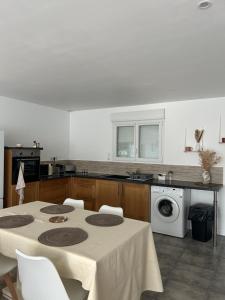 una cucina con tavolo e lavatrice di Maison avec jardin en Provence a Oraison