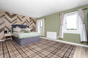a bedroom with a bed and two windows at 2 Bedroom House-Free Parking in Rosyth +21 photos