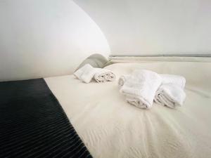 a white bed with towels on top of it at Suite Brescia 10 - Sanremo in Sanremo +2 photos