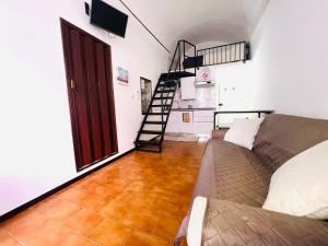 a living room with a couch and a stair case at Suite Brescia 10 - Sanremo in Sanremo