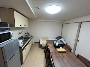 大阪市にあるApartment House Jodo 301の小さな客室で、キッチンとテーブルが備わります。