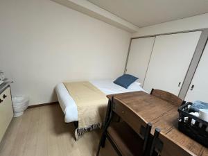 大阪市にあるApartment House Jodo 301のベッドとテーブルのある小さな寝室