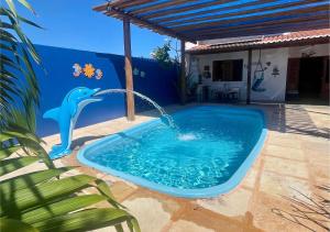 a dolphin water fountain in a swimming pool at Casa em Pontal de Maceió by Holiday Stays in Maceio