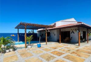 a house with a patio with palm trees in front of it at Casa em Pontal de Maceió by Holiday Stays in Maceio