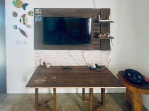 a wooden table with a flat screen tv on a wall at Casa em Pontal de Maceió by Holiday Stays in Maceio