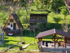 a small house with a gazebo and a playground at Cabana Samira Tășnad in Tăşnad