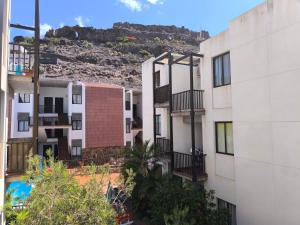 プラヤ・デ・サンティアゴにあるRolin Apartmentの背景に丘のあるアパートメントビル