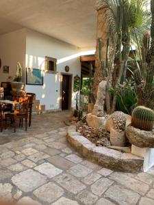 a patio with a table and chairs and cactus at Felline In Bed&Breakfast Dimora di Charme el Salento in Felline
