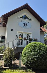 a white house with a balcony with flowers on it at Pension Miss Sophie in Kyritz