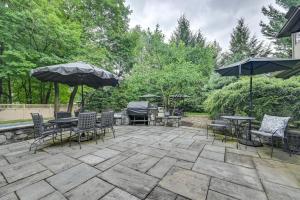 a patio with tables and chairs and umbrellas at Hot Tub, Gym, Game Room! Luxe Estate in Longmeadow in Longmeadow