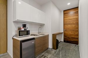 a small kitchen with a sink and a microwave at Business studio-apartment near the beach in Cancún