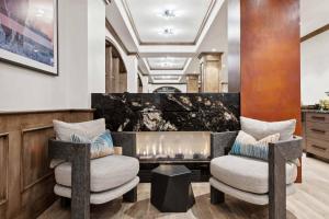 a living room with two chairs and a fireplace at Lodge Tower 290 in Vail