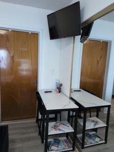 a room with two tables and a flat screen tv at Welcome Heart and Reliable Heart Vacation Houses in Miami
