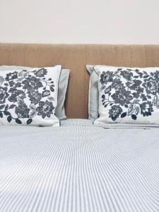 two beds with black and white sheets and pillows at Rabumba - Aveiro Central Lodging in Aveiro