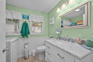 a bathroom with a sink and a toilet and a mirror at 28 Seconsett Point Road Mashpee - Betty's By The Bay in Mashpee +55 photos
