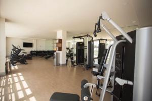 a gym with several treadmills and exercise bikes at Classic 2BR Condo pool near beach in Cancún