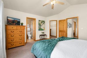 a bedroom with a bed and a dresser and a bathroom at Rigden Retreat Garage, Dog Friendly, Near Trails in Fort Collins
