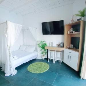 a room with a bed and a table and a tv at Sunshine Bungalow in Schitul