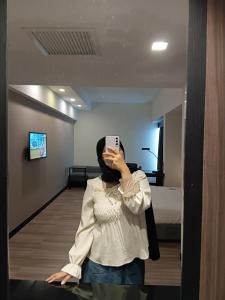a woman taking a picture of herself in a mirror at Politeknik metro kl in Kuala Lumpur