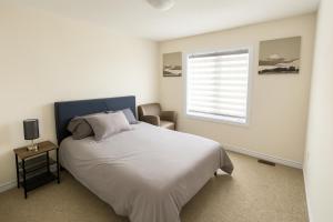 Postel nebo postele na pokoji v ubytování Central & Cozy 2BR Townhome with Free Parking, WiFi, Full Kitchen, Laundry, Steps to Strip Plaza & 5 Min Drive to Innisfil Beach Park! Perfect for Work Trips, Family Travel & Couples!