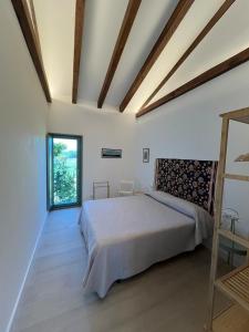 a bedroom with a bed and a large window at A CASIÑA dos LARANXOS in Cenlle