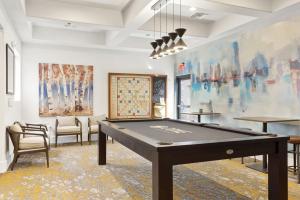 einen Billardtisch in einem Zimmer mit Gemälden in der Unterkunft Boulevard Stays 2BR by Stadium Pool Parking Gym 10 in Glendale