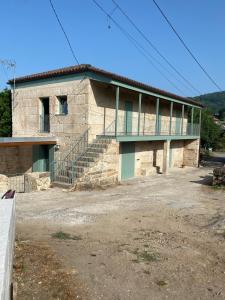 a stone building with a staircase in front of it at A CASIÑA dos LARANXOS in Cenlle