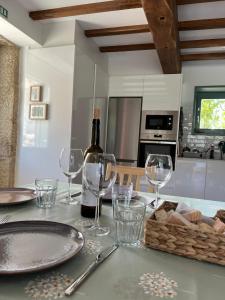 a bottle of wine sitting on a table with glasses at A CASIÑA dos LARANXOS in Cenlle