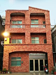 a red brick building with a balcony at Mir Homestay in Lieyu