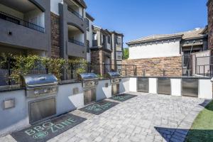 eine Terrasse mit einem Grill vor einem Gebäude in der Unterkunft Boulevard Stays 1BR by Stadium Pool Parking Gym 01 in Glendale