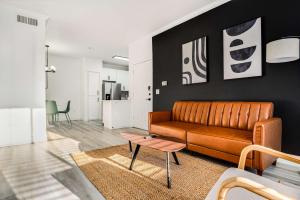 ein Wohnzimmer mit Sofa und Tisch in der Unterkunft Boulevard Stays 1BR by Stadium Pool Parking Gym 01 in Glendale + 17 Fotos