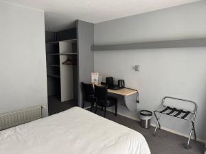 a bedroom with a bed and a desk with chairs at Hôtel Dupleix - Hyper centre - Réouverture in Quimper