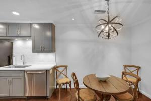 Una cocina con una mesa y sillas y una lámpara de araña. en Ocean Walk D-3, en Saint Simons Island