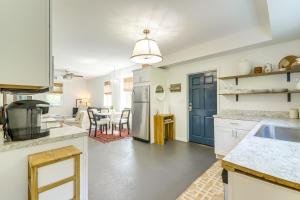 una cocina con armarios blancos y una puerta azul en 4 Mi to UGA Bright and Airy Athens Apartment!, en Athens