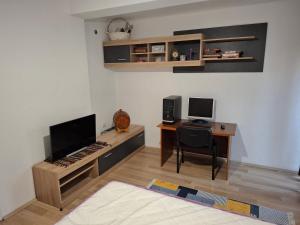 Habitación con escritorio, ordenador y teclado. en Pancho Apartment's, en Kumanovo