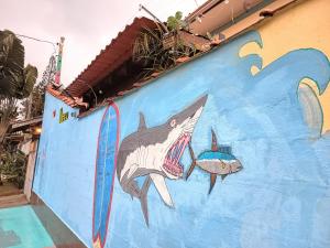 a painting of a shark on the side of a wall at Ubatuba Wild Surf House in Ubatuba