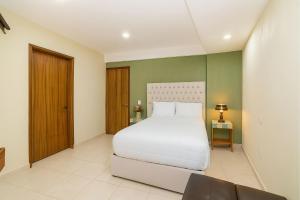 Un dormitorio con una cama blanca y una pared verde. en Casa Santa Fe, en Guanajuato 26 fotos más