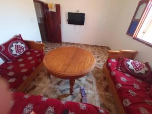 a living room with a table and a couch at Chezidar Tafadna Essaouira in Aït Mellal