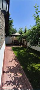 a brick walkway next to a grassy yard with a tree at Casa Maxim - relaxare în verde in Pantelimon