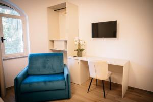 a living room with a blue chair and a desk at Villa Nicadè in Corbara